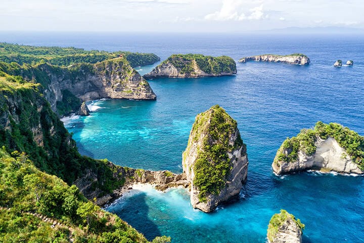 Aerial view on a sunny day of the small island of Nusa Batumategan and Nusa Batupadasan Island from the Atuh Rija Lima shrine on Nusa Penida Island near Bali, Indonesia.
