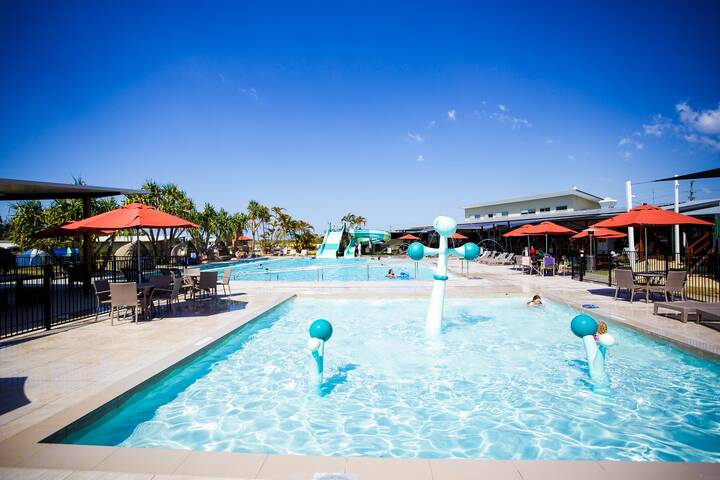 Rivershore's large swimming pool features exciting water slides, inflatable tubes for kids, and a shallow paddle pool. The vibrant, family-friendly area invites guests to enjoy a fun-filled day of water activities in a lively setting.