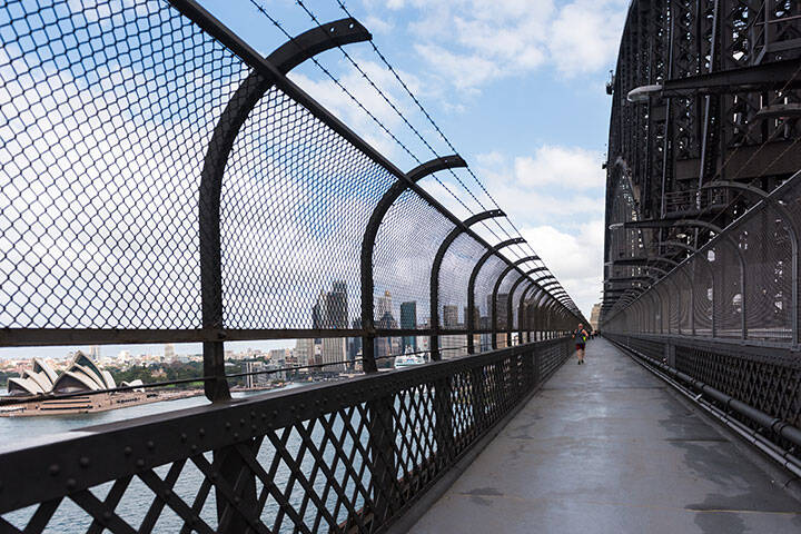People walking and running on the popular pedestrian walkway on the Sydney Harbour Bridge in Australia