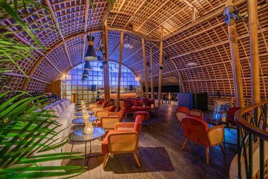 Indoor dining area with cane archway over tables and chairs at Akar Restaurant in Ubud, Bali